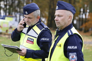 Dwóch policjantów ubranych w mundury z napisami policja .